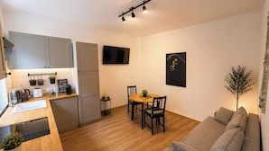 A compact living space with a kitchenette, dining area, and seating area. - Elegant Boutique Apartment with Luxury Bedroom (Bucharest)