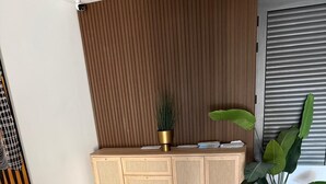 Une salle de bain moderne avec un meuble-lavabo en bois, un grand miroir et une plante en pot.