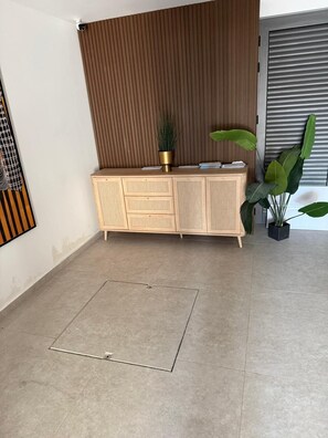Ein modernes Badezimmer mit einem Holzkosmetikschrank, einem großen Spiegel und einem Blumentopf.