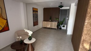 Un intérieur moderne comprenant un coin repas, un canapé et une table basse agrémentée de fleurs.