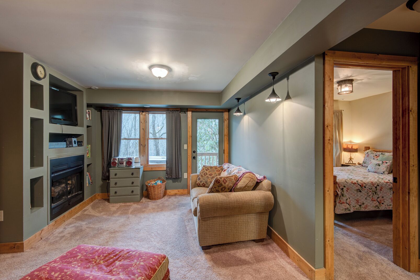 A cozy room with a fireplace, a sofa, a bed, and a small table.