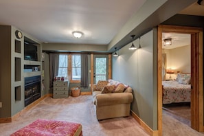 A cozy room with a fireplace, a sofa, a bed, and a small table. - Appalachian Retreat (Blowing Rock)