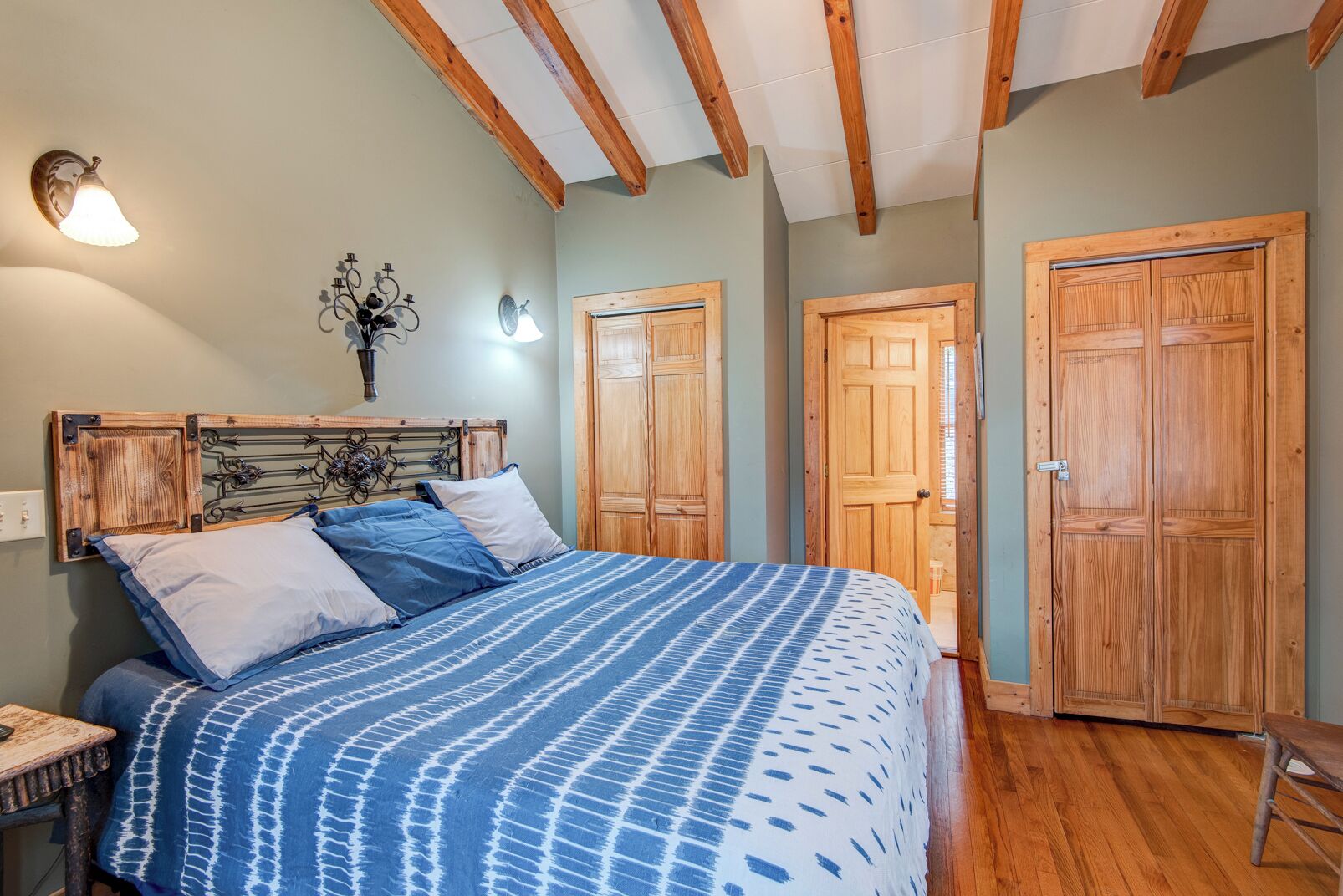 Un dormitorio con cama, armario de madera y mesita de noche.