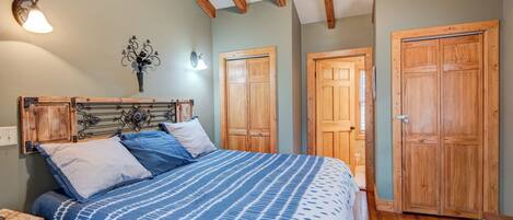 Un dormitorio con cama, armario de madera y mesita de noche.