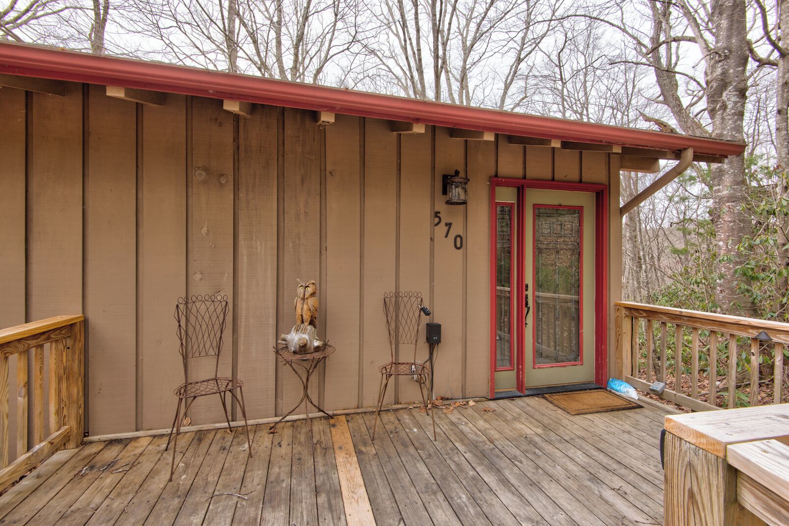 A wooden cabin with a red door and number 570 on the wall.