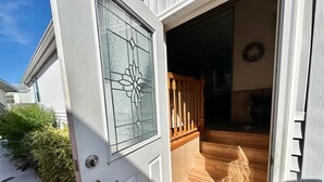 A white door with a glass panel and a wooden staircase leading inside. - Cal's Retreat N617 (Jensen Beach)