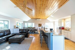 A modern kitchen with a central island, wooden ceiling, and large windows. - Alpenglow (Blowing Rock)