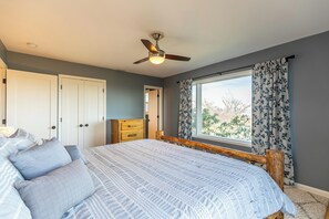 A bedroom with a bed, a ceiling fan, a window with curtains, and a wardrobe. - Alpenglow (Blowing Rock)