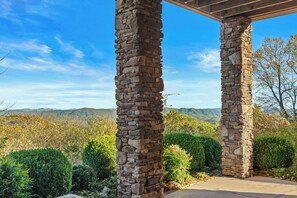 Eine Pergola aus Stein mit Blick auf eine gebirgige Landschaft.