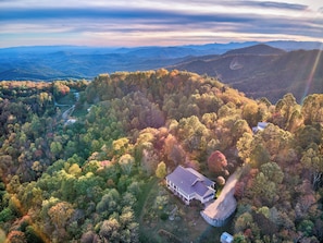 Ein Haus, umgeben von Wald mit Blick auf ferne Berge.