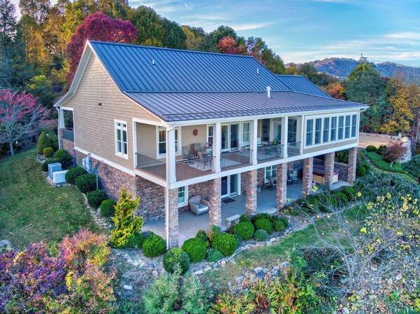 A two-story house with a balcony, stone foundation, and a metal roof. - Mountain Lilly - Huge Views, Three Ensuites, 10min to Blowing Rock (Lenoir)