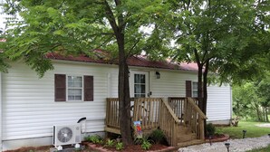 A single-story house with a front porch, a small deck, and a front yard with a pathway. - Rocky Hill Retreat (Rocky Hill)