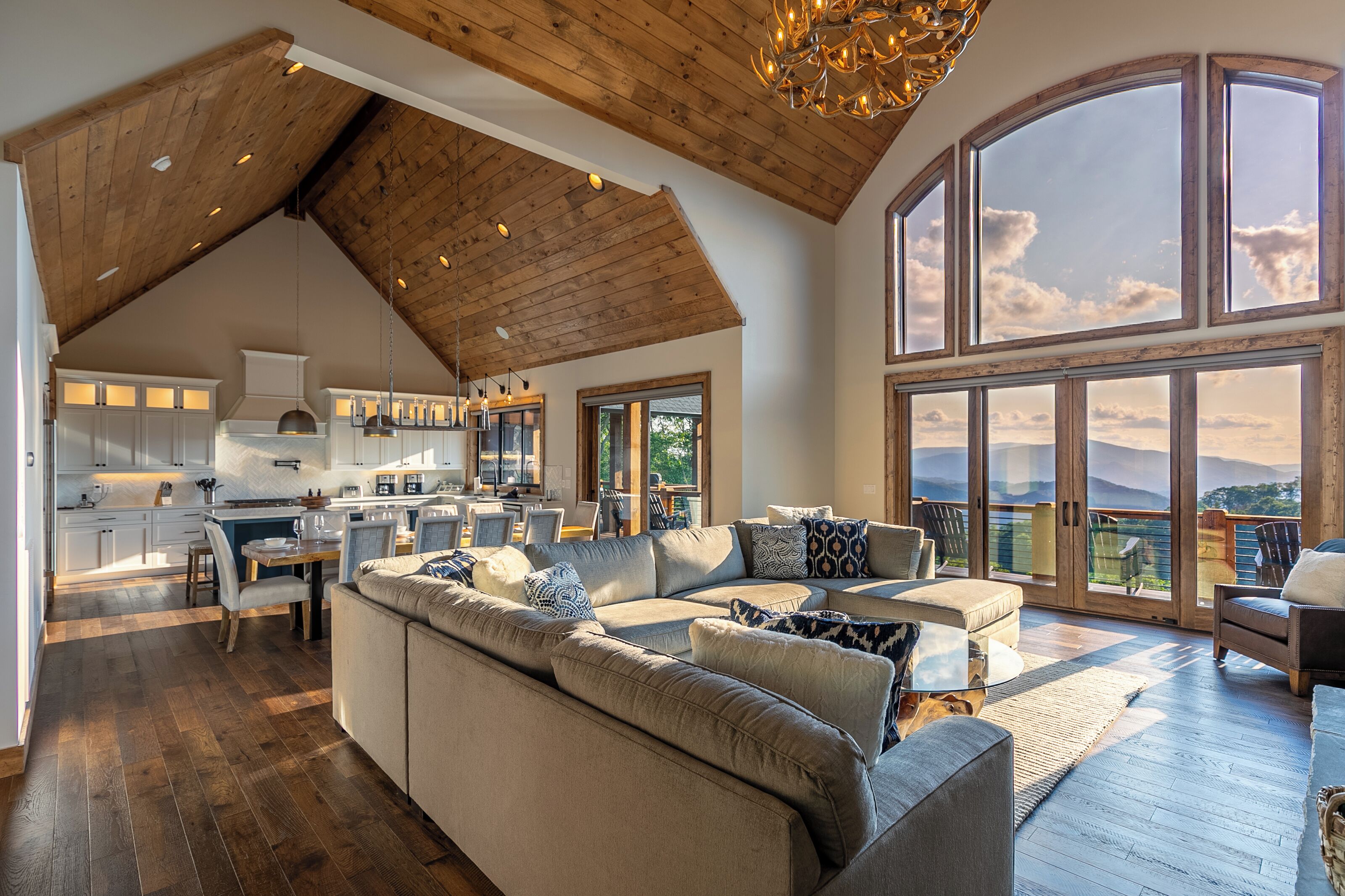 A spacious living area with a large sofa, a dining table, and a kitchen in the background.