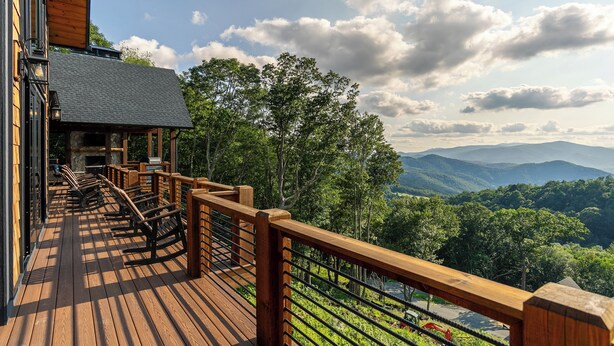 A wooden deck with outdoor seating, overlooking a mountainous landscape. - Up and Away at Eagles Nest (Banner Elk)