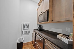 A compact kitchen with a microwave, coffee machine, and a trash bin. - Up and Away at Eagles Nest (Banner Elk)