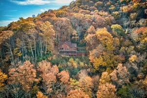 Una casa rodeada de follaje otoñal en un bosque.