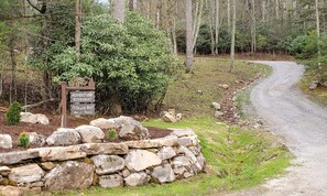 A stone wall with a sign indicating an Adventure Hideaway and 75 Eagles Nest on Mann's Trail. - Adventure Hideaway at Eagles Nest (Banner Elk)