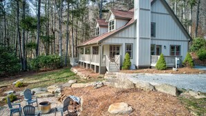 A two-story house with a porch, surrounded by a forest. - Adventure Hideaway at Eagles Nest (Banner Elk)