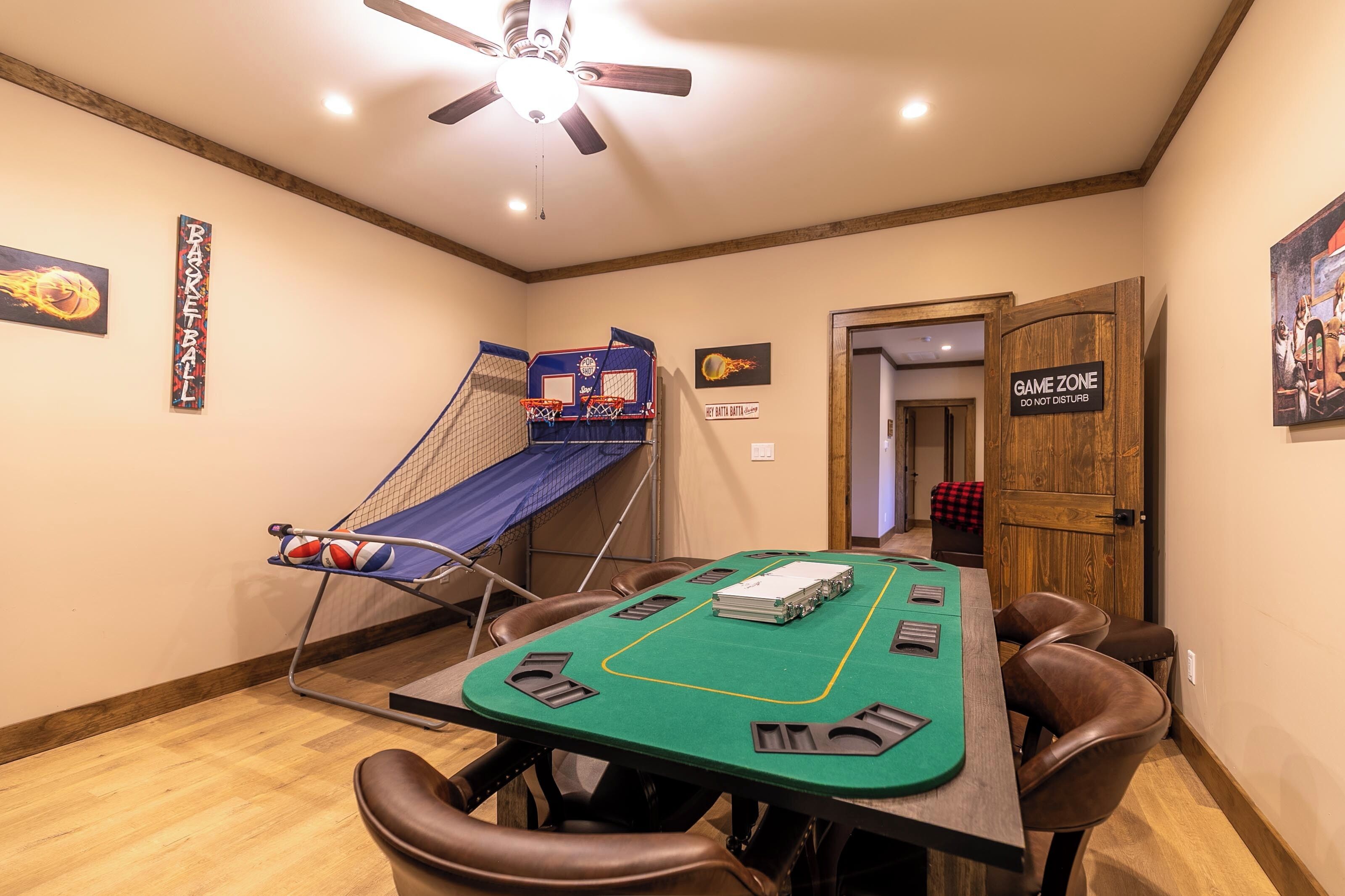 Une pièce équipée d’une table de billard, d’un ventilateur de plafond, d’un panier de basket et d’une porte sur laquelle est inscrit : « ESPACE DE JEU – NE PAS DÉRANGER ».