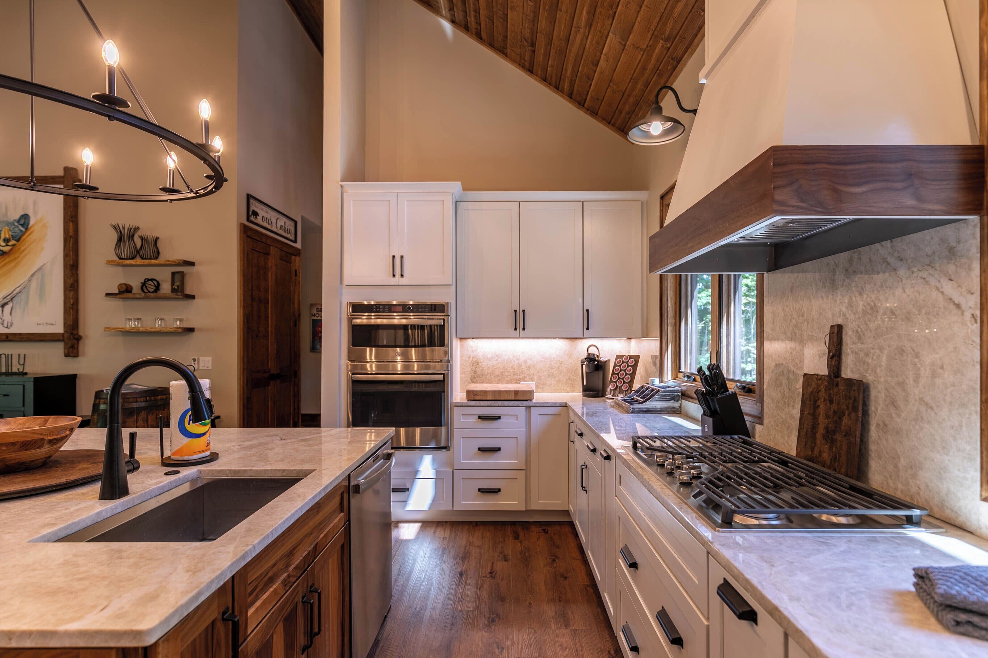 Een moderne keuken met een centraal eiland, roestvrijstalen apparatuur en houten keukenkastjes.