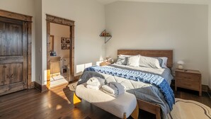 Ein Schlafzimmer mit einem hölzernen Bett, einem Nachttisch, einem Beistelltisch und einem Holzschrank.