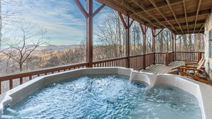 A hot tub under a wooden deck with a view of mountains. - Journeys End at Valle Crucis (Banner Elk)