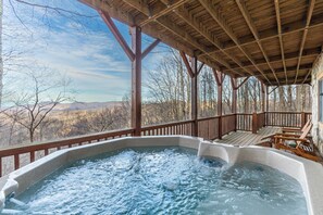A hot tub under a wooden deck with a view of mountains. - Journeys End at Valle Crucis (Banner Elk)