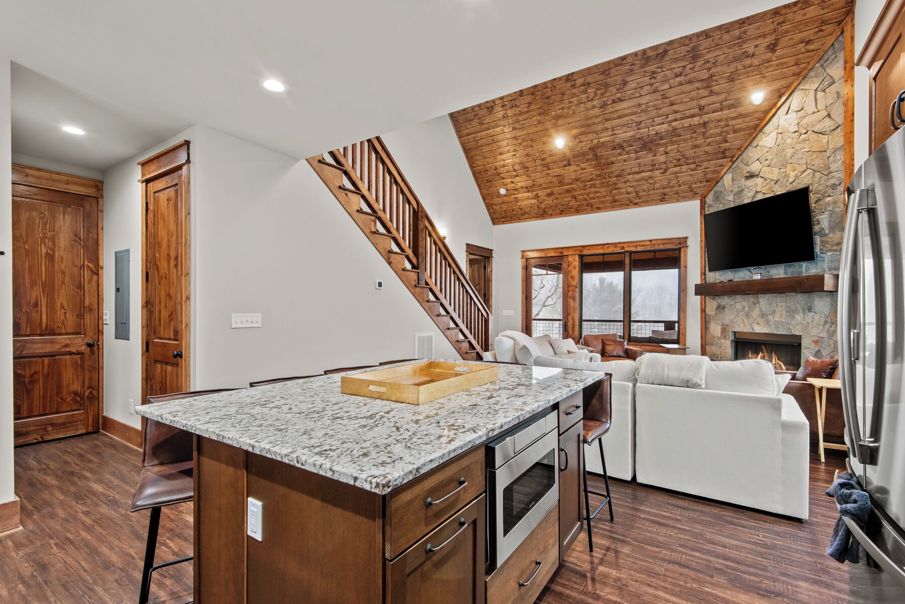A modern kitchen with a marble countertop, wooden cabinets, and a built-in oven.