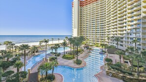 A hotel with a large pool area, a beach view, and a high-rise building. - Shores of Panama 521 (Panama City Beach)