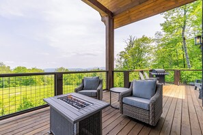 A wooden deck with wicker furniture, a fire pit, and a grill. - Just Bluffin' at Eagles Nest (Banner Elk)