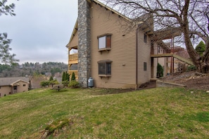 A two-story house with a stone chimney, a balcony, and a small deck. - Chetola Robin 1 (Blowing Rock)
