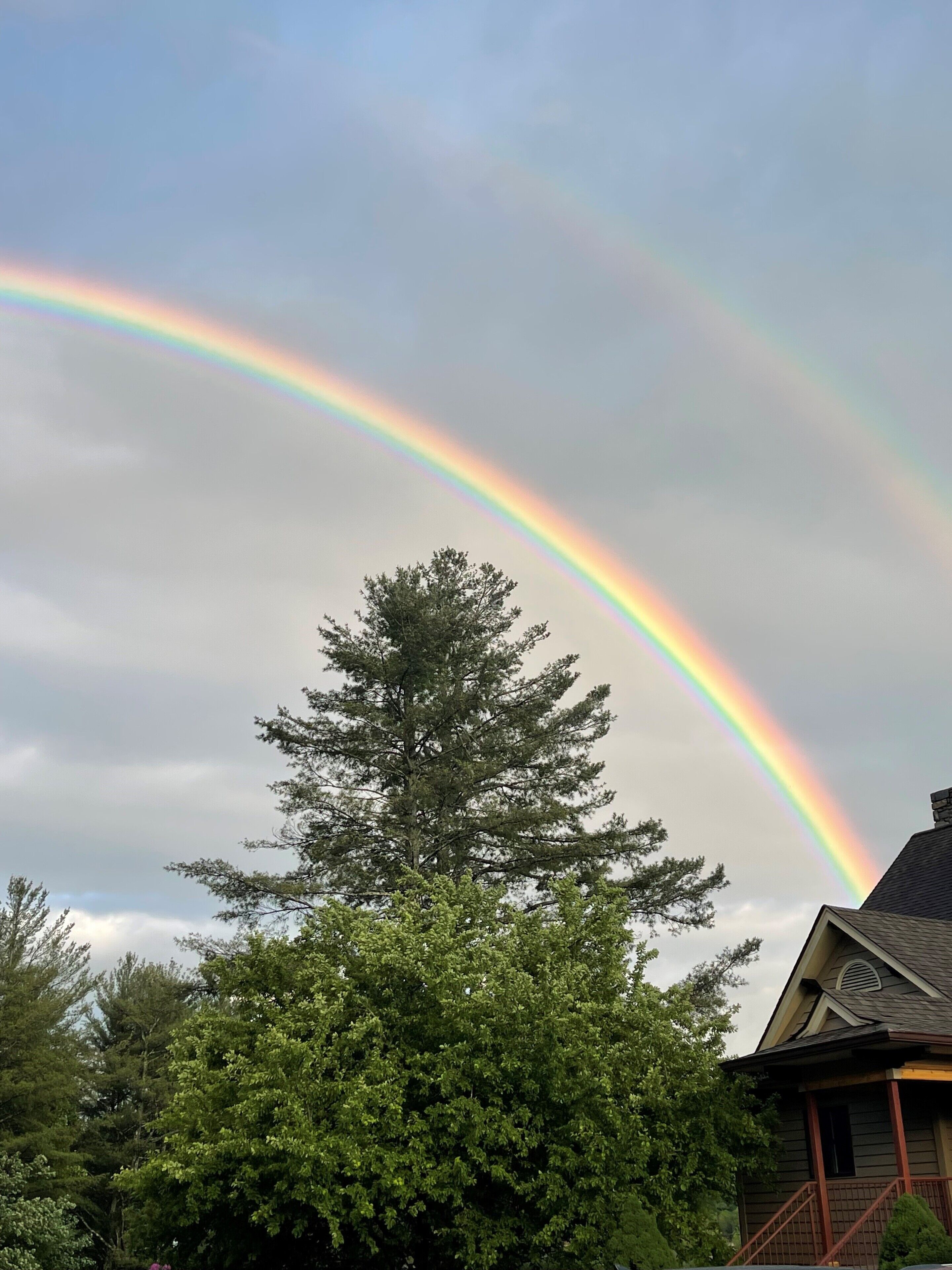 Una casa con un arcobaleno che la sovrasta.