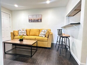 Ein Wohnzimmer mit einer Couch, einem Couchtisch und einem Barhocker.