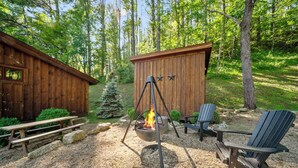 A wooden cabin with a fire pit, a picnic table, and Adirondack chairs. - Red Wolf Chalet at Eagles Nest (Banner Elk)