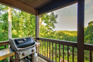 A covered outdoor area with a grill and a view of a forested landscape. - Appaljack Retreat (Blowing Rock)