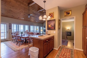 A spacious kitchen with wooden cabinets, a large island, and a dining area with chairs. - Hangin' Out - Stunning Mountain Views, Garage, Jacuzzi Tub (Blowing Rock)