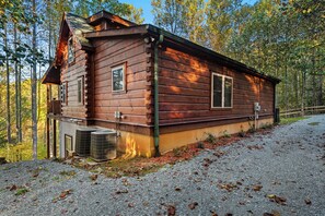 A wooden cabin with a chimney, two windows, and an air conditioning unit. - Falling Waters (Banner Elk)