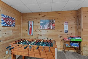 A room with a foosball table, a gas station mural, and a Jeep gas pump sign. - Falling Waters (Banner Elk)