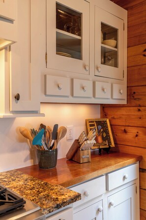 A kitchen with white cabinets, a granite countertop, and various utensils. - Mountaintop at Yonahlossee Saddle Club (Boone)