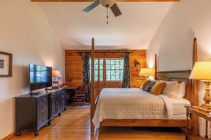 Ein Schlafzimmer mit Bett, Kommode, Fernseher und Deckenventilator.