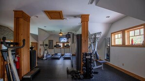 Ein Fitnessstudio mit Laufbändern, Crosstrainern und Gewichten.