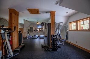 Ein Fitnessstudio mit Laufbändern, Crosstrainern und Gewichten.