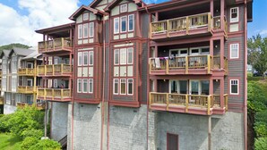Ein mehrgeschossiges Wohngebäude mit Balkonen, einer Stein-Fassade und blauem Himmel.
