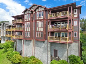 Ein mehrgeschossiges Wohngebäude mit Balkonen, einer Stein-Fassade und blauem Himmel.