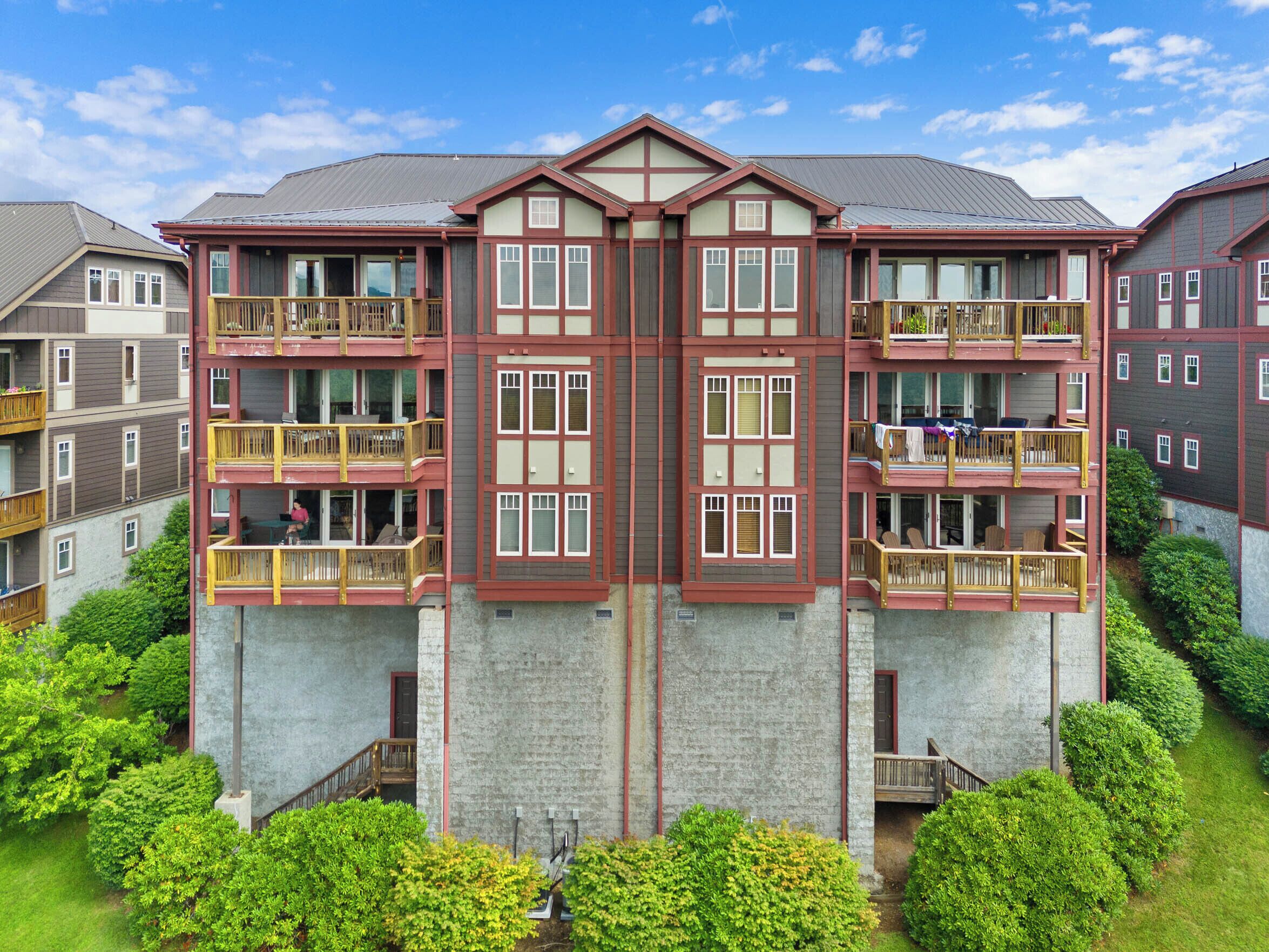 A multi-story building with balconies, a stone facade, and a clear sky.