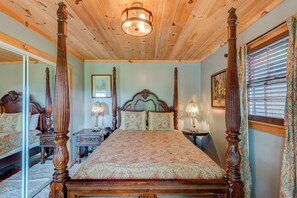 A four-poster bed with a floral bedspread, a wooden ceiling, and a large mirror on one wall. - Crystal View (Boone)