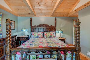 A four-poster bed with floral bedding, wooden headboard, and matching side tables with lamps. - Crystal View (Boone)