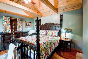 A bedroom with a four-poster bed, wooden ceiling beams, a wooden dresser, and a nightstand with a lamp. - Crystal View (Boone)