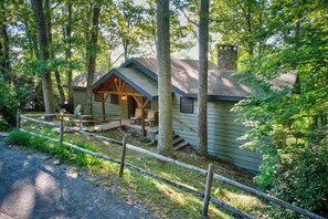 A cabin with a porch, a stone chimney, and a fenced yard. - Crystal View (Boone)