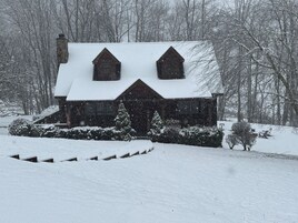 Una casa cubierta de nieve con un techo pronunciado y dos ventanas de tejado a dos aguas.